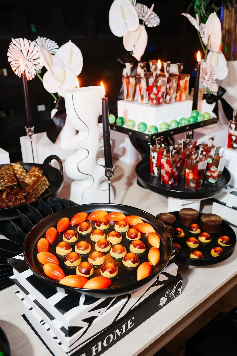 Passed bites on a black tray beside candles