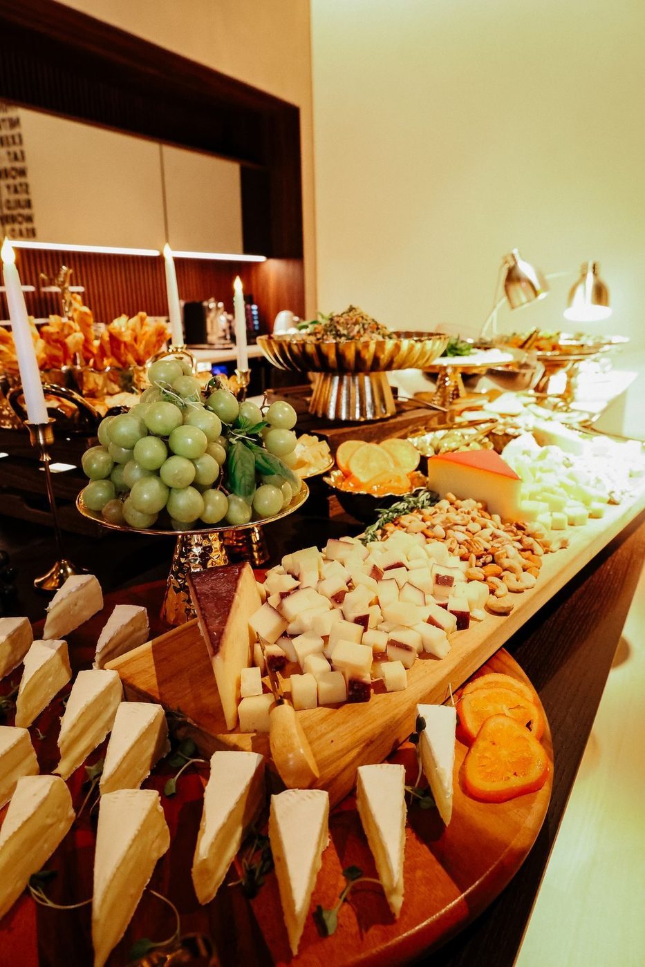 Cheese wedges and grapes on a long board