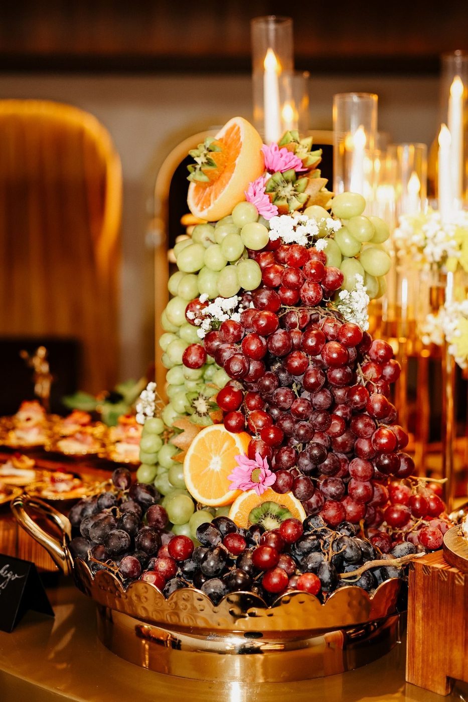 Fruit and floral tower among candles
