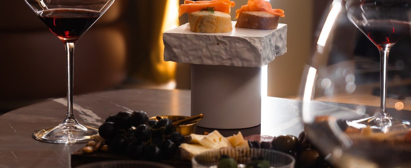 Wine glasses and grazing boards on a marble table in a dark lounge