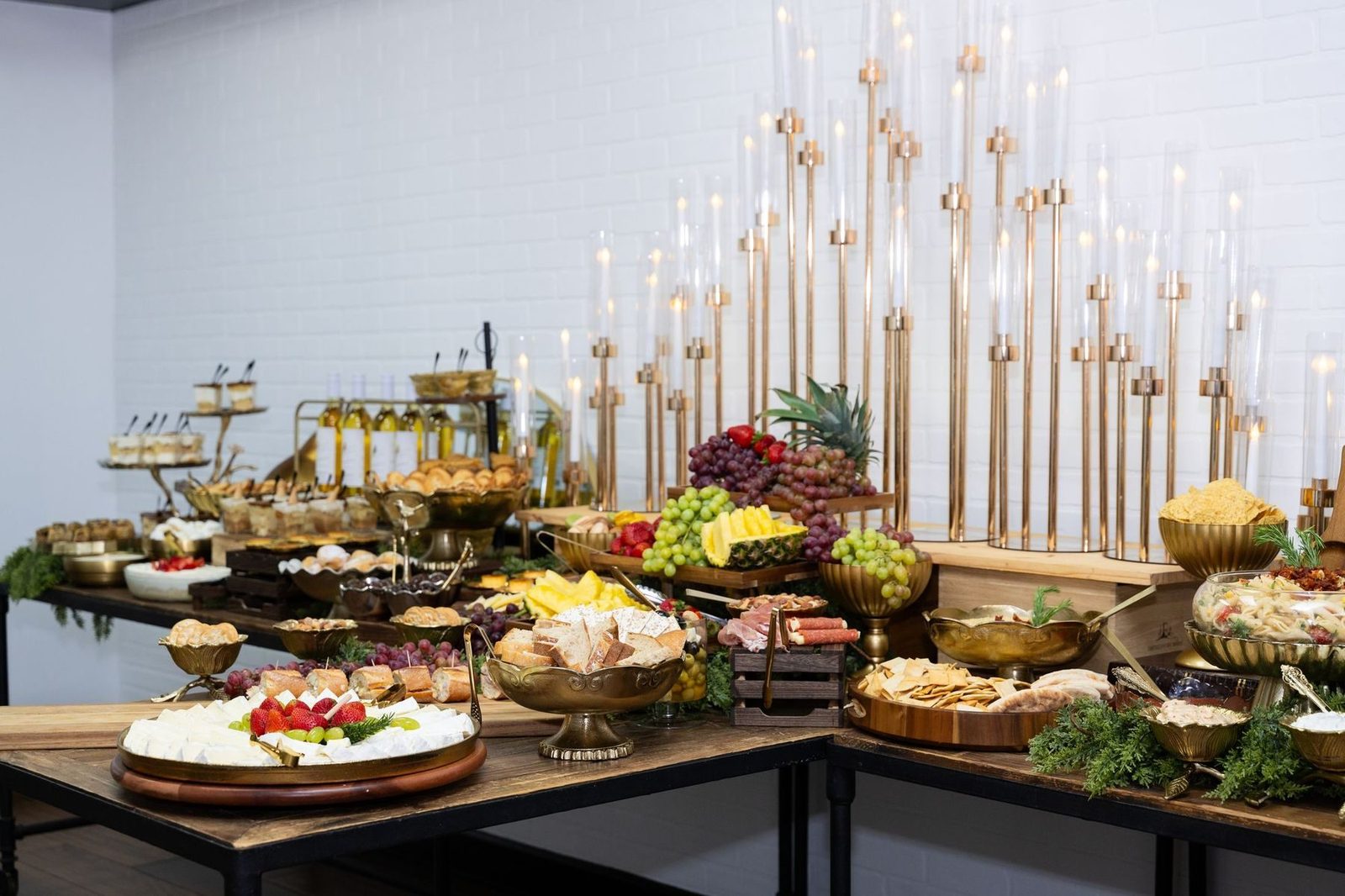 Long grazing table with fruit, cheeses and gold candelabra